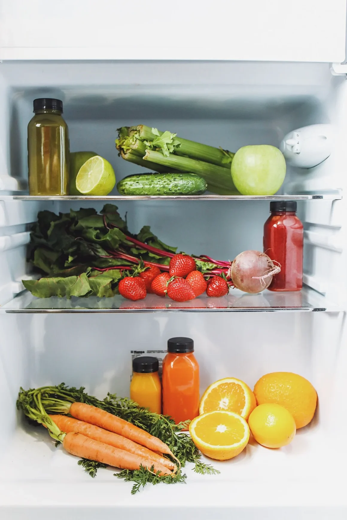 Fresh fruit, vegetables and bottled drinks on refrigerator shelves; illustrative grocery image, not the listed store.