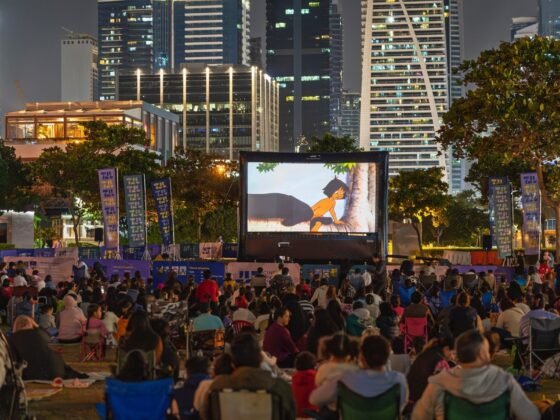 Outdoor cinema audience surrounded by JLT towers at night