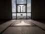 Open window in a sunlit room overlooking city buildings